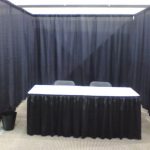 Black expo or convention style post and drape, with skirted table